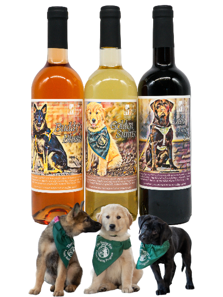 Three wine bottles with custom labels: Buddy's Blush shows a GSD in harness, Golden Sunrise has a golden puppy in a bandana, and Labs Love Red has a chocolate Lab pup in a puppy vest.