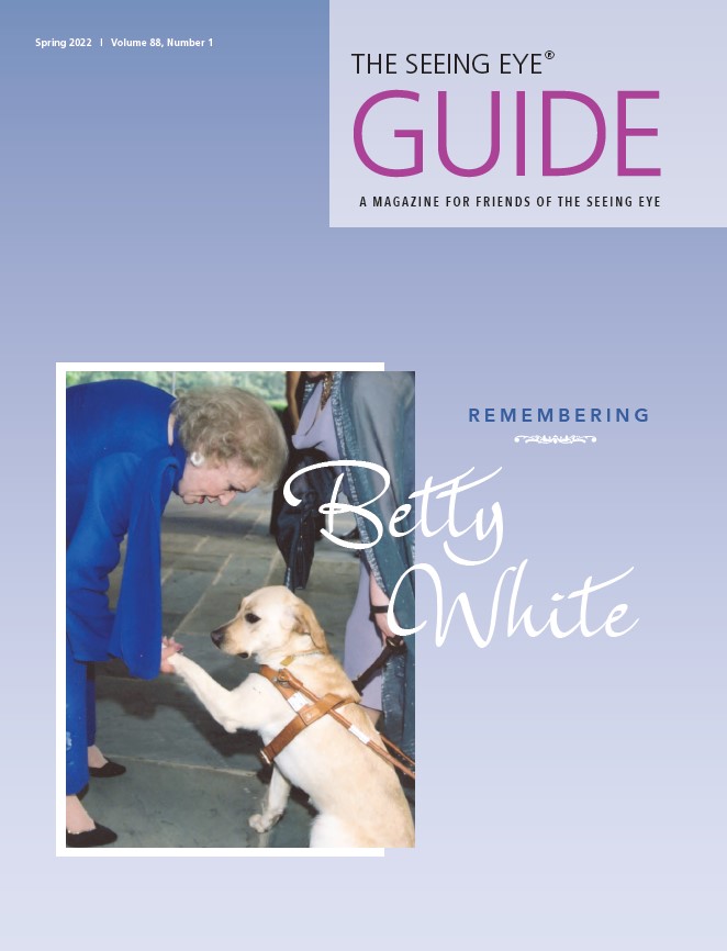 The cover of The Guide Spring 2022 shows Betty White bending over to greet a yellow Labrador retriever in harness. The cover text reads: 'Remembering Betty White.'
