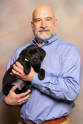 James Hands holding a 7-week-old female black Labrador/golden retriever cross.