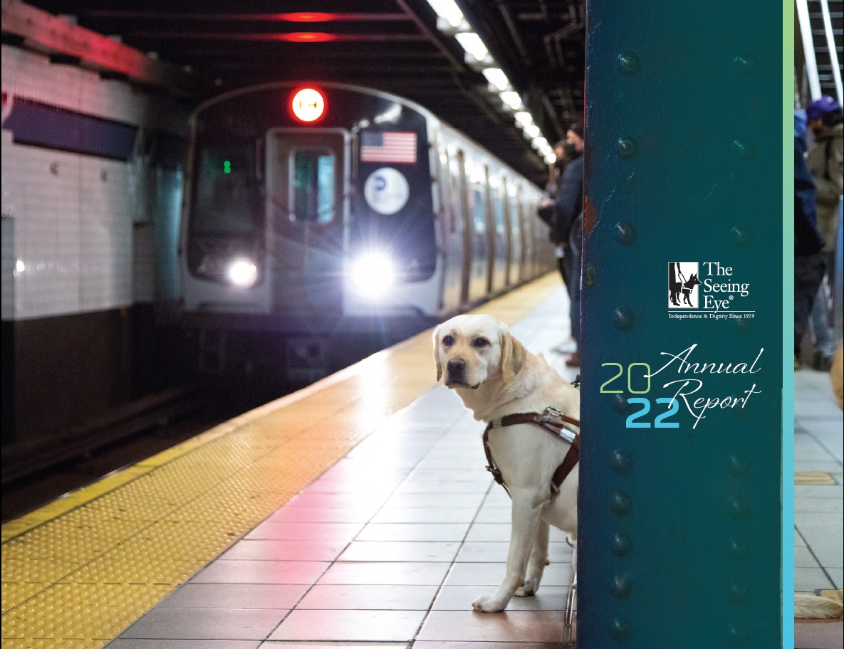 The cover of The Seeing Eye Annual Report 2022 shows a yellow Labrador retriever, in harness, sitting calmly on a platform as a subway train pulls into the station.